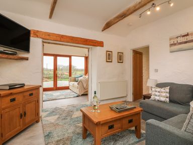 A living room with wooden furniture sofas and rugs at Edwin's View in Nancegollan nr Porthleven