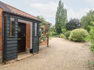 An entrance with a gravel path and a rose bush at Lowbrook Cottage Dickleburgh near Diss