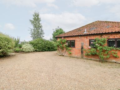 An outdoor area with a brick wall and gravel surface at Lowbrook Cottage Dickleburgh near Diss