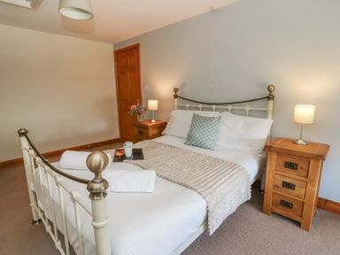 A bedroom with a bed and bedside lamp at Glanyrafon in St Harmon