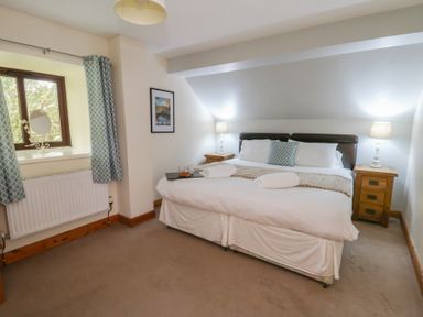 A bedroom with a bed and window at Glanyrafon in St Harmon