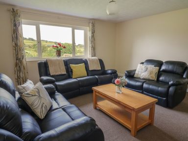 A living room with sofas and a coffee table at Glanyrafon Bungalow St Harmon