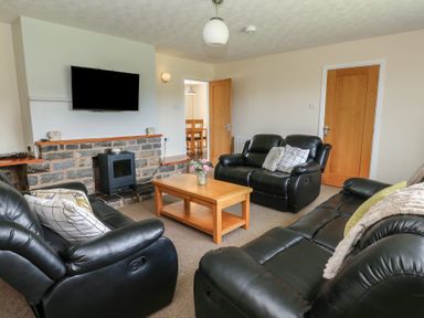 A living room with a sofa and coffee table at Glanyrafon Bungalow in St Harmon