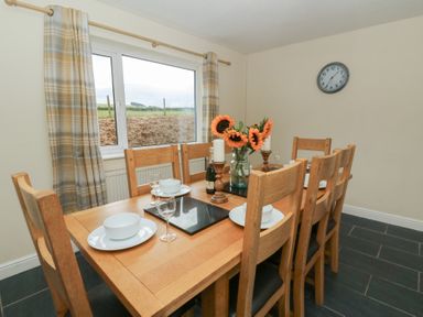 A dining room with a table set for meals at Glanyrafon Bungalow St Harmon