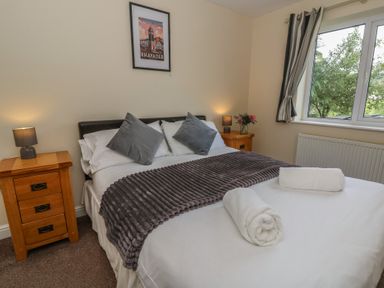 A bedroom with a large bed and bedside tables at Glanyrafon Bungalow in St Harmon