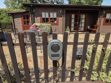 An outdoor area with a table and chairs at Tythe Lodge – Hot Tub Retreat in Rural Lincolnshire | Family-Friendly Lodge Near Heckington