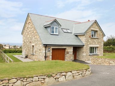 A detached stone house with a slate roof and garage at Myles View in Pendeen