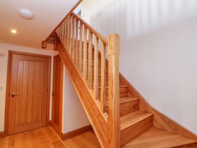 A wooden staircase next to two wooden doors in a hallway at Apple Tree Cottage in Bleatarn near Kirkby Stephen