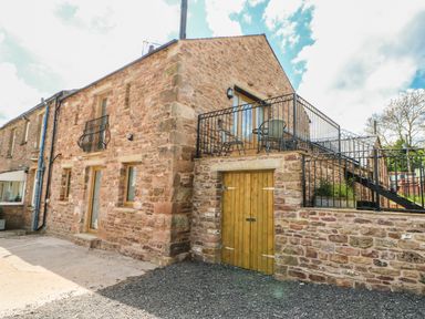 Stone building with balcony and outdoor furniture at Apple Tree Cottage in Bleatarn near Kirkby Stephen