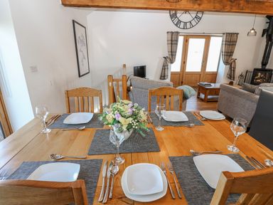 A dining room with a wooden table set for dinner at Apple Tree Cottage Bleatarn near Kirkby Stephen