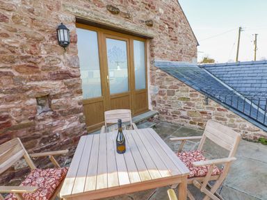 A seating area with a table and chairs at Apple Tree Cottage Bleatarn near Kirkby Stephen