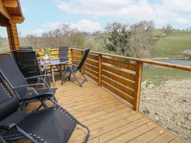 A patio with chairs and a table at Manor Farm Lodges - Red Kite Lodge in Newtown
