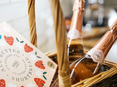 A wicker basket containing two bottles of sparkling wine and a box of strawberry and clotted cream shortbread at Holly Edge in Moorsholm