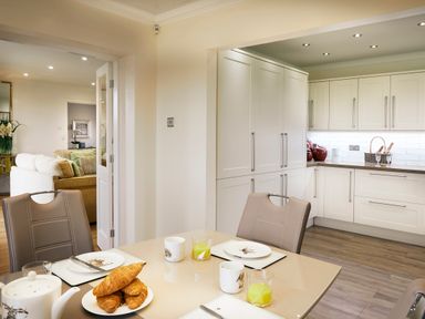 A kitchen with white cabinets a table set with croissants mugs and glasses with drinks at Holly Edge in Moorsholm
