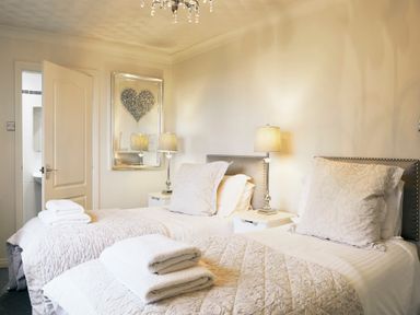 A bedroom with two single beds bedside lamps and a heart decoration on the wall at Holly Edge Moorsholm