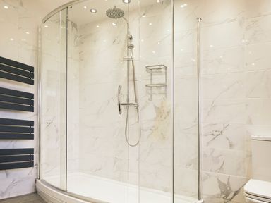 A bathroom with a curved glass shower enclosure and a chrome showerhead at Holly Edge in Moorsholm