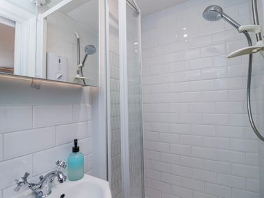 A shower and sink area in a bathroom at Lily Cottage in Looe