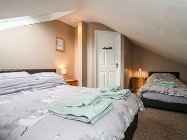 A bedroom with two beds and folded towels on them at Fisher Granary in Lampeter