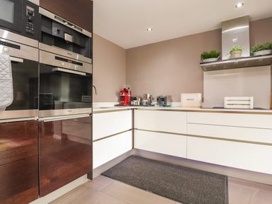 A kitchen with built-in ovens a coffee machine toaster bread box and plants at Underfell in Burton-In-Kendal