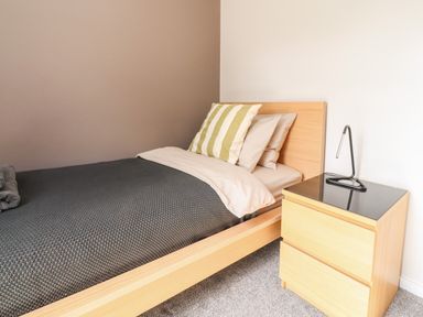 A bedroom with a wooden bed a bedside table and a lamp at Underfell in Burton-In-Kendal