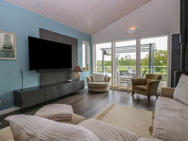 A living room with a tv and sofa at Links View in Fritton