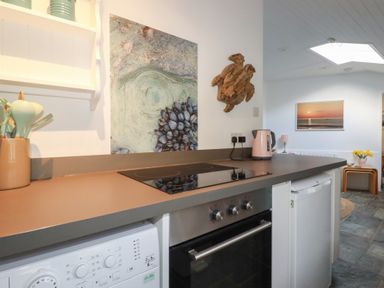 A kitchen with a countertop and appliances at Smugglers Cottage Trebarwith Strand near Tintagel