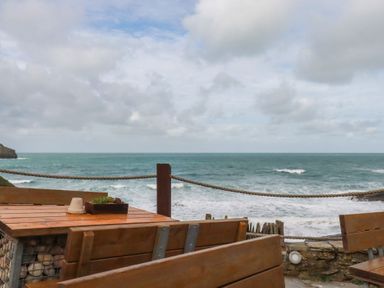 A table and chairs overlooking the ocean at Smugglers Cottage Trebarwith Strand near Tintagel