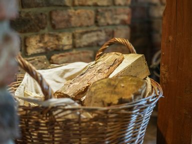A basket with chopped firewood against a brick wall at Manor Cottage in Northallerton