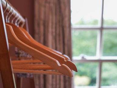 Wooden hangers on a rack near a window with curtains at Manor Cottage in Northallerton