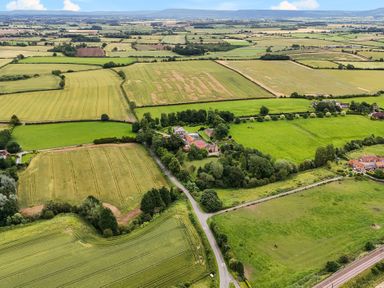 An aerial view of fields and farmland with a cluster of buildings and roads at Manor Cottage in Northallerton