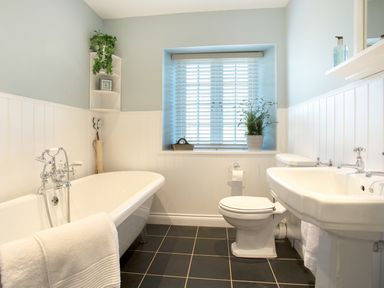 A bathroom with a bathtub toilet sink and window with blinds at Penlaurel in Launceston