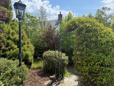 A garden with a lamp post and an arch at Penlaurel in Launceston