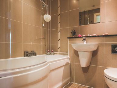 A bathroom with a bathtub sink and toilet at Dragonfly in Bridgwater