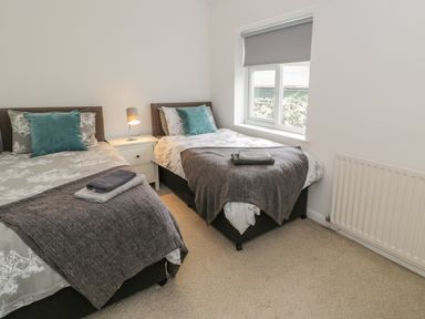 A bedroom with two single beds and a window at Hendre Wylan in Llanaber