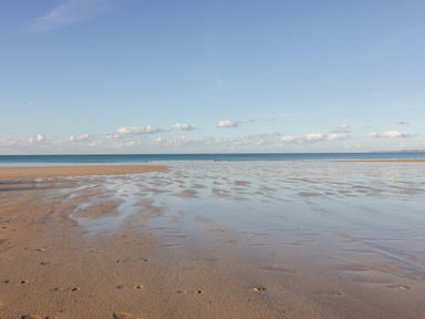 A sandy beach with shallow water and the sea under a clear sky at Onshore 6 - Newquay Towan Beach View in Newquay