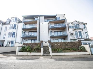 The front view of a modern apartment building with balconies and a staircase leading up to the entrance at Onshore 6 - Newquay Towan Beach View in Newquay