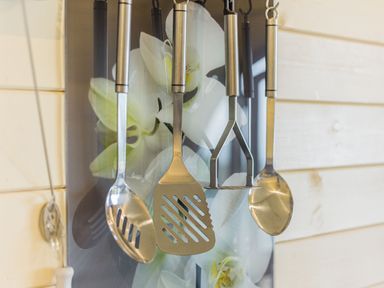 Kitchen utensils including spoons spatulas and a masher hanging on a kitchen wall at Stiperstones Pod in White Grit near Chirbury