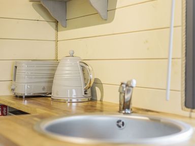 A kitchen countertop with a kettle toaster and sink at Stiperstones Pod in White Grit near Chirbury