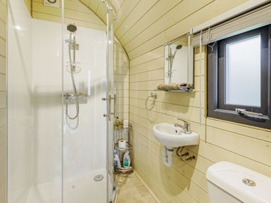 A bathroom with a corner shower cubicle sink toilet and window at Stiperstones Pod White Grit near Chirbury