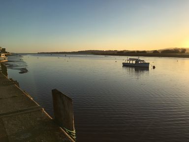 A river with a boat anchored near the shore and a concrete pier at Upham View in Woodbury