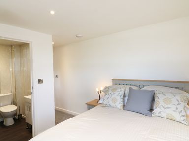A bedroom with a bed and pillows next to an en suite bathroom at Upham View in Woodbury