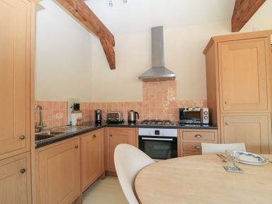 A kitchen with cabinets and appliances at Upper Mill Barn Coln St Aldwyns near Bibury