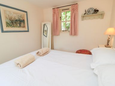 A bedroom with a bed and towels on it at Upper Mill Barn, Coln St Aldwyns, near Bibury