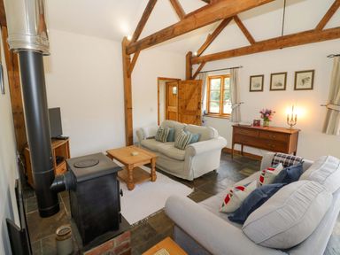 A living room with a sofa and coffee table at Robbie's Barn Fulready near Stratford-upon-Avon