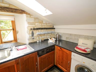 A kitchen with appliances and a window at Robbie's Barn Fulready near Stratford-upon-Avon