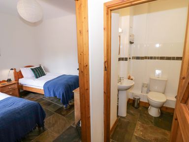 A bedroom with two beds and a bathroom at Robbie's Barn Fulready near Stratford-upon-Avon