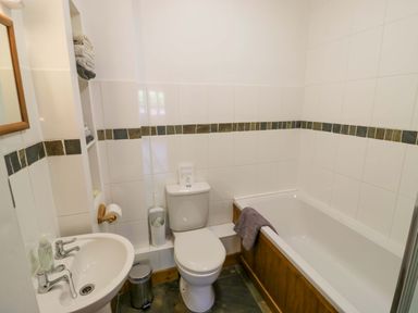 A bathroom with a sink, toilet, and bathtub at Robbie's Barn Fulready near Stratford-upon-Avon