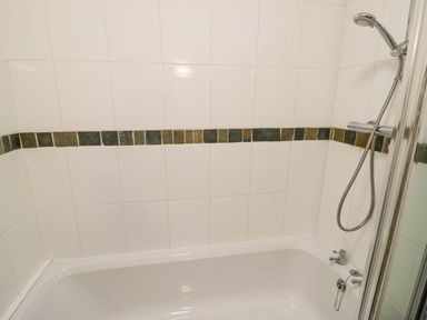 A bathroom with a bathtub and shower at Robbie's Barn Fulready near Stratford-upon-Avon