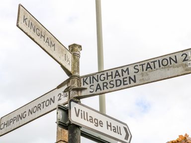A set of old metal directional road signs pointing to Kingham Kingham Station Sarsden Chipping Norton and Village Hall