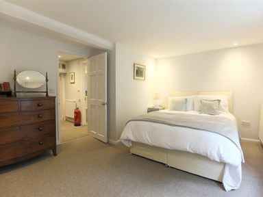 A bedroom with a bed and a wooden chest of drawers at Hare House in Chipping Norton